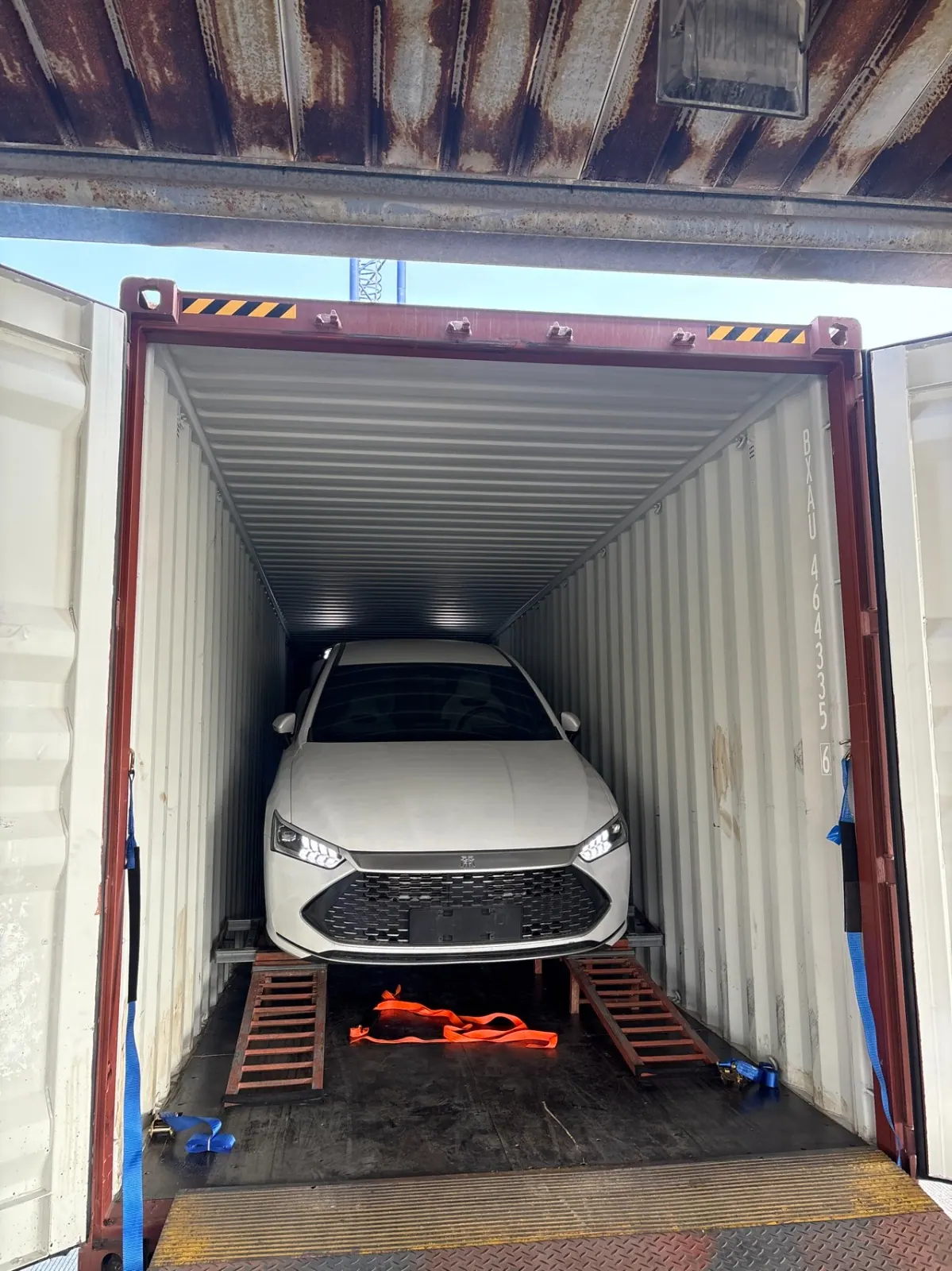BYD sedan loaded on ramps inside a Sino Gear export container